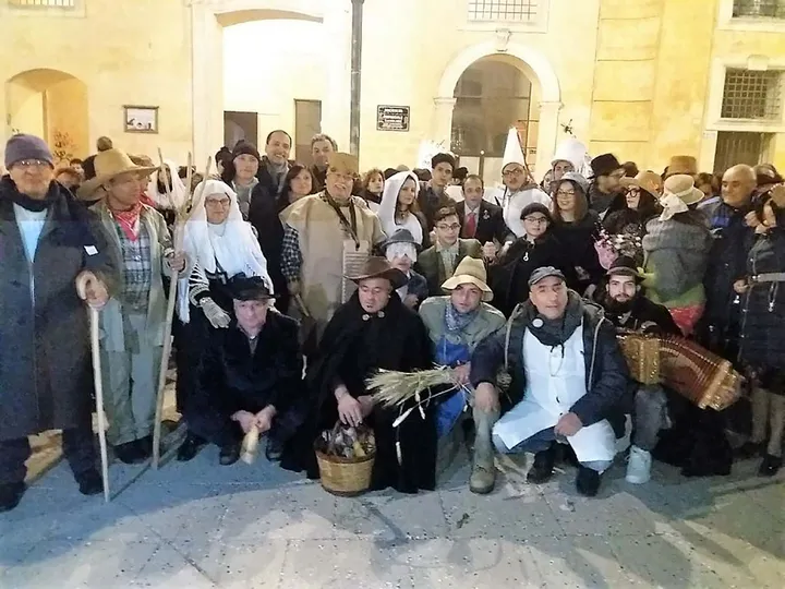 Il gruppo dei figuranti del Carnevale di Cirigliano in posa davanti a un portone del borgo