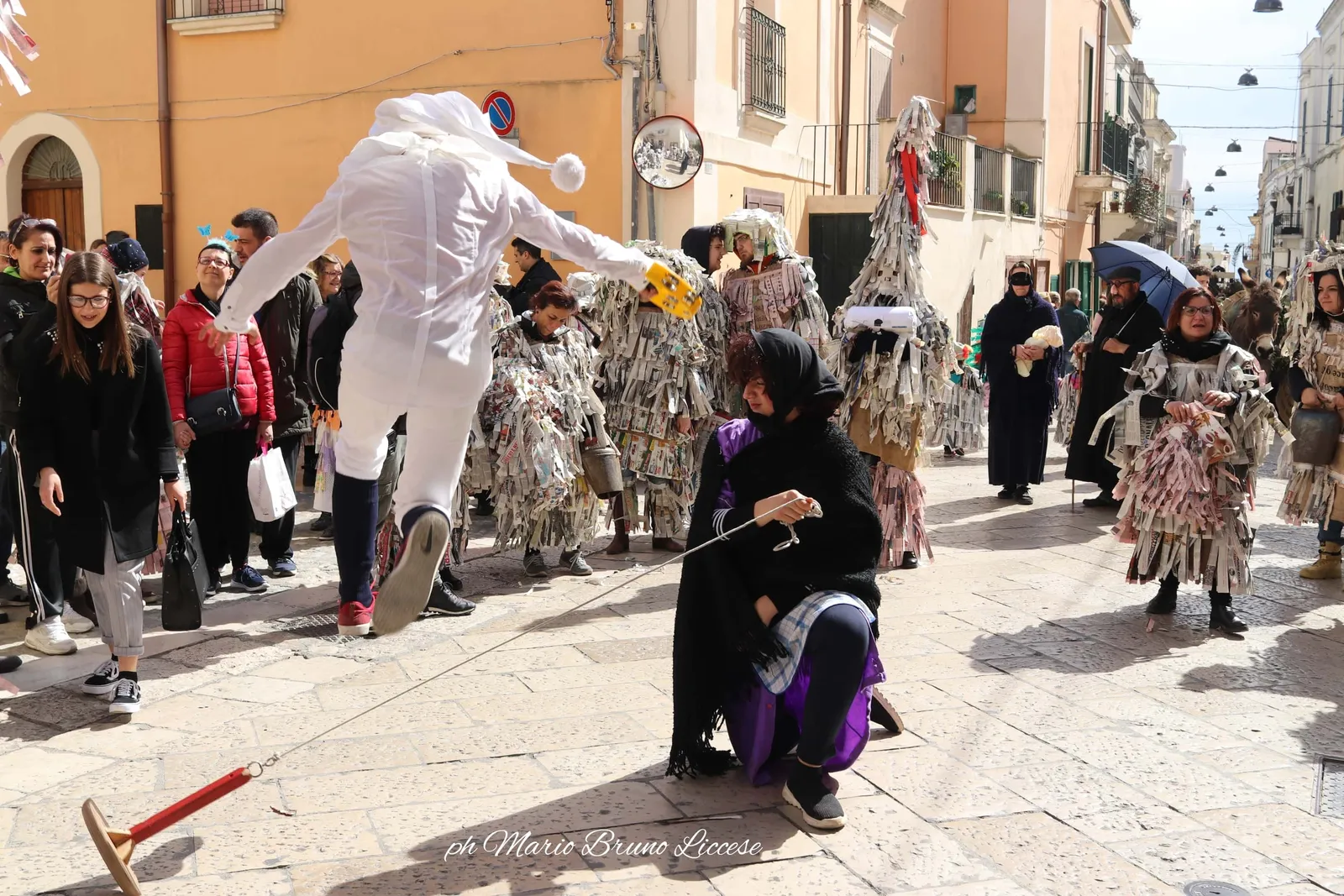 Il corteo del Carnevalone di Montescaglioso: una figura vestita di bianco svetta fra le maschere ricoperte di strisce di carta